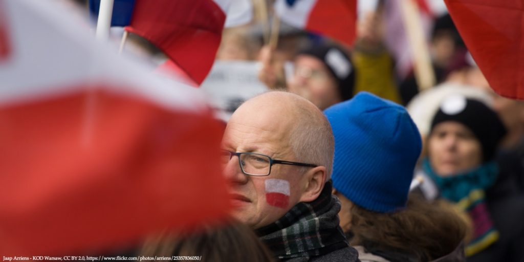 Policy Brief Image of a Man and Polish Household Representative with Polish Flags Days Before Government Elections