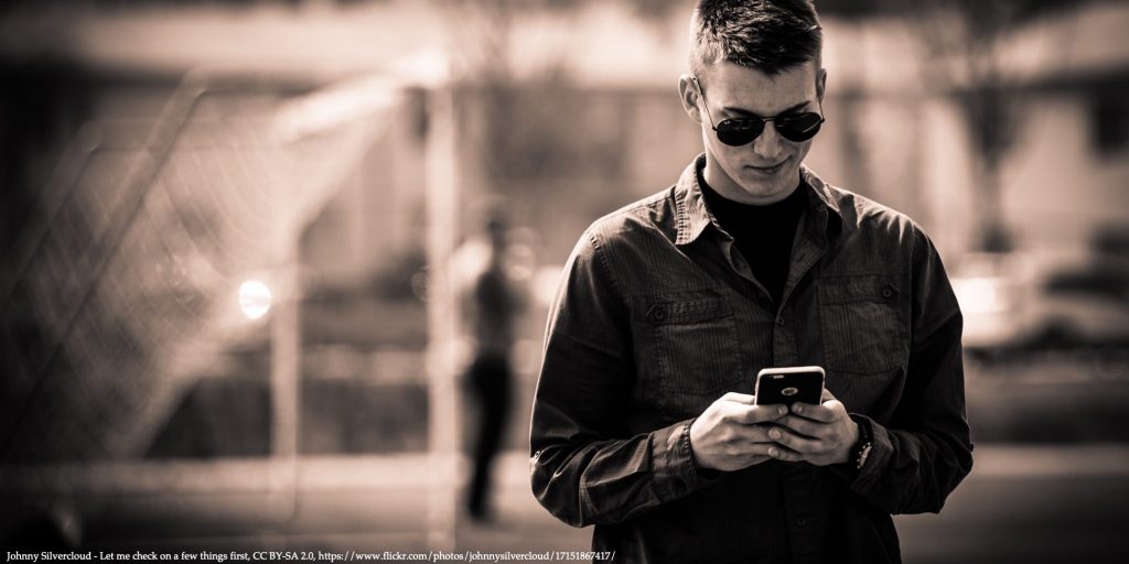 Man with a cell phone in hands spending time on social media