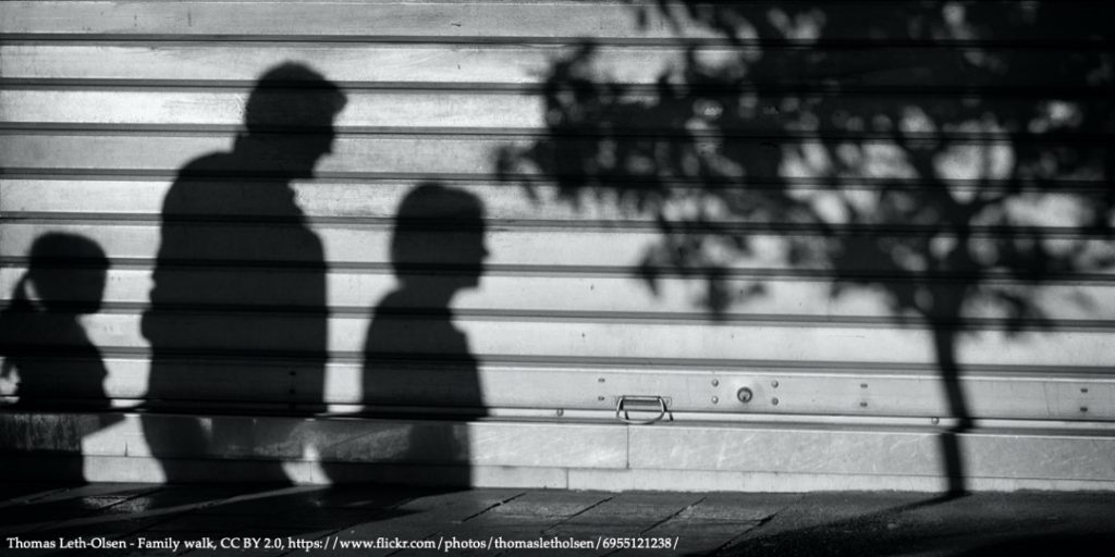 Shadow on the wall with a family of three people representing current economics of childbearing