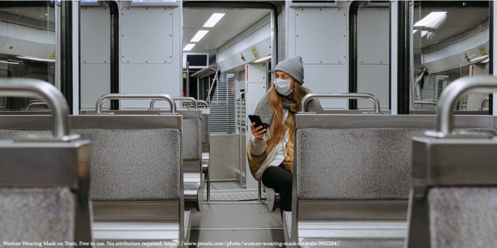 An image of a woman sitting in a public transport with a COVID-19 protection mask on the face representing the Covid-19 pandemic in Eastern Europe