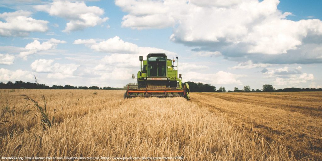 An image of the wheat field with with grain harvester representing food security