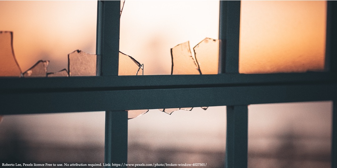 A view of a window with broken glass representing representing perspectives of domestic violence