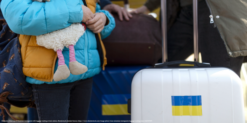 Image depicting Ukrainian refugees, including a child holding a teddy bear, eagerly awaiting their return to Ukraine