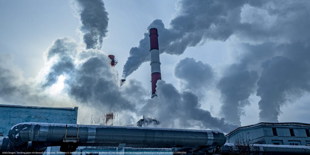 Power plant emitting smoke, illustrating the economic impact of emissions on the environment.