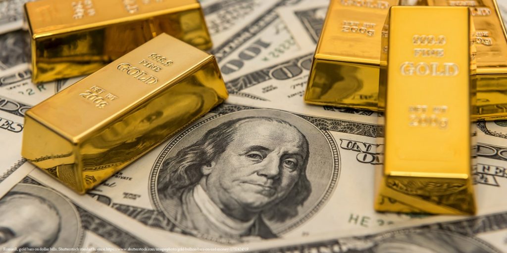 Gold bars on US dollar bills representing Georgia's recent acquisition of gold valued at 500 million dollars to diversify reserves