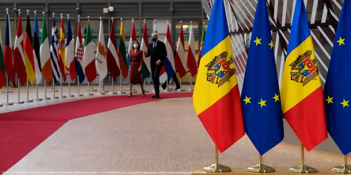 Flags of Moldova and the European Union at a diplomatic meeting, symbolizing Moldova's EU integration efforts.